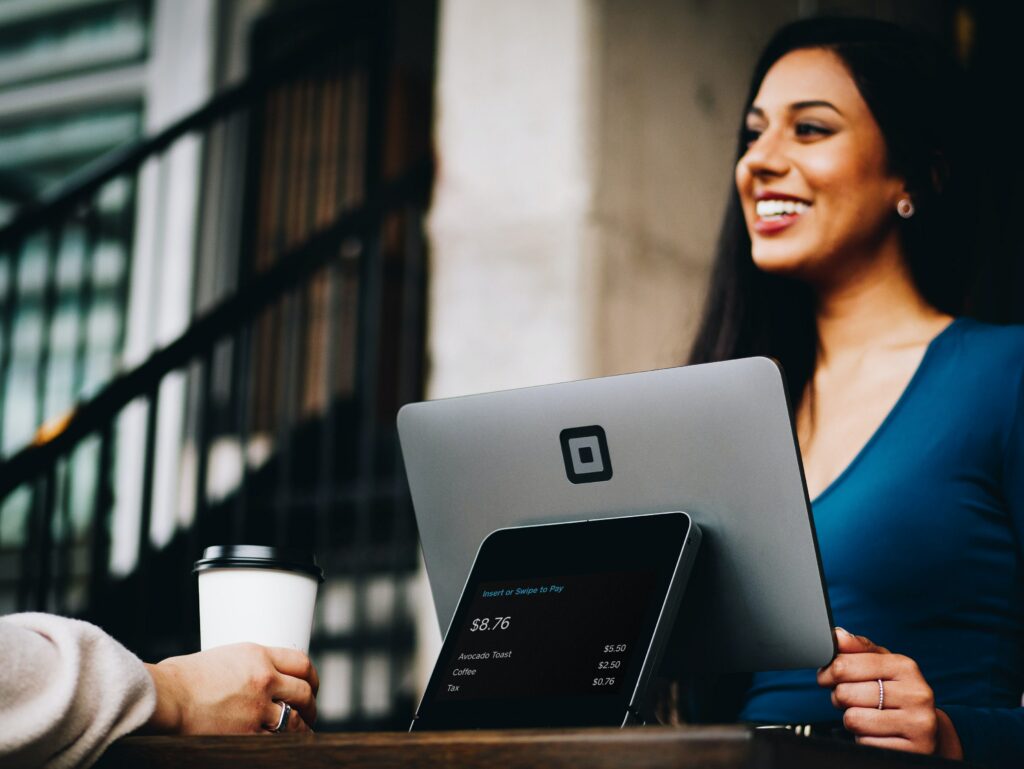 Una mujer feliz trabaja con una tableta en un entorno empresarial