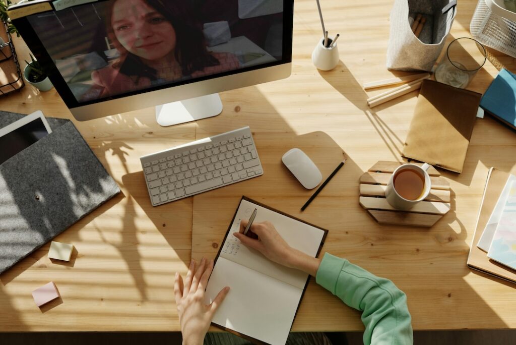virtual meeting, woman taking notes. How to take effective meeting notes