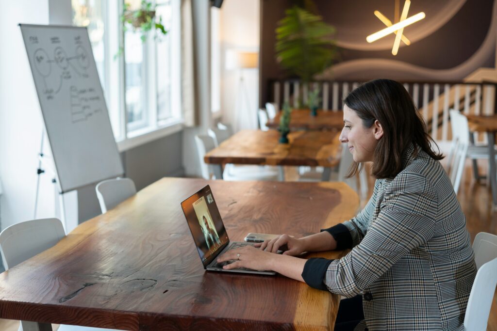 Bild einer Person, die an einem Schreibtisch sitzt und ein Benutzerinterview führt, mit einem Whiteboard im Hintergrund